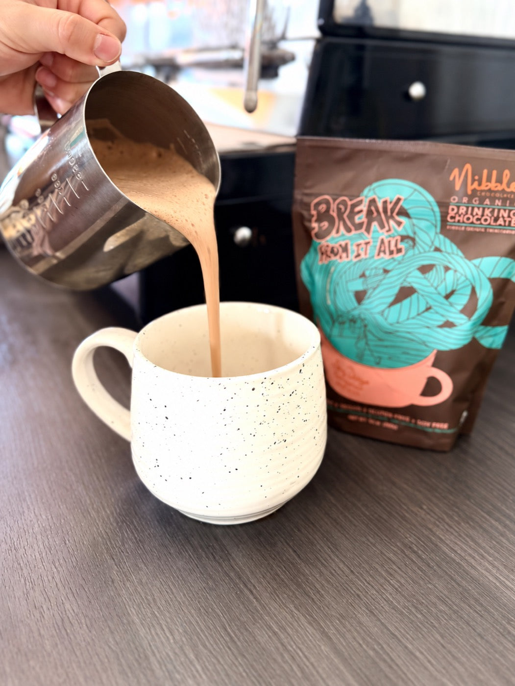 Hot chocolate being poured into a café cup